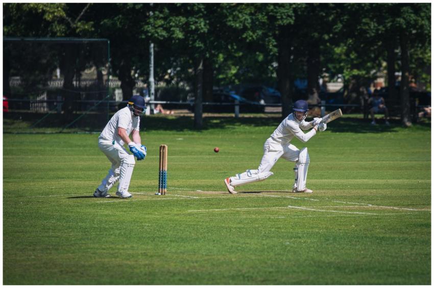 Two cricket players in action during a sunny match