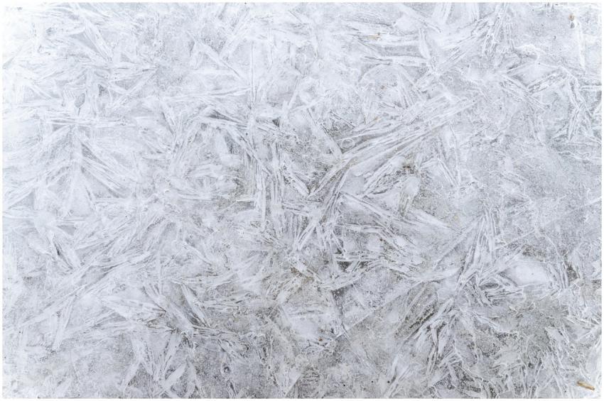 A detailed close-up of frosty ice patterns creatin