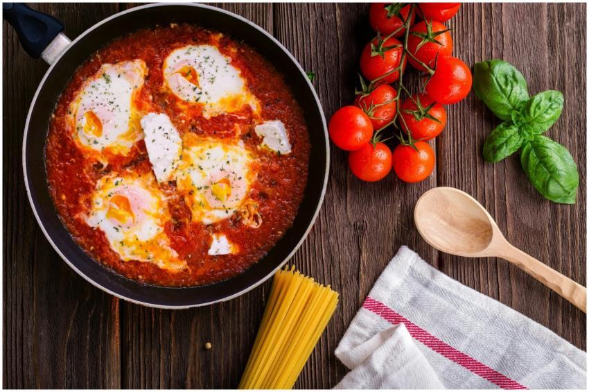 Delicious eggs in tomato sauce with basil, spaghet