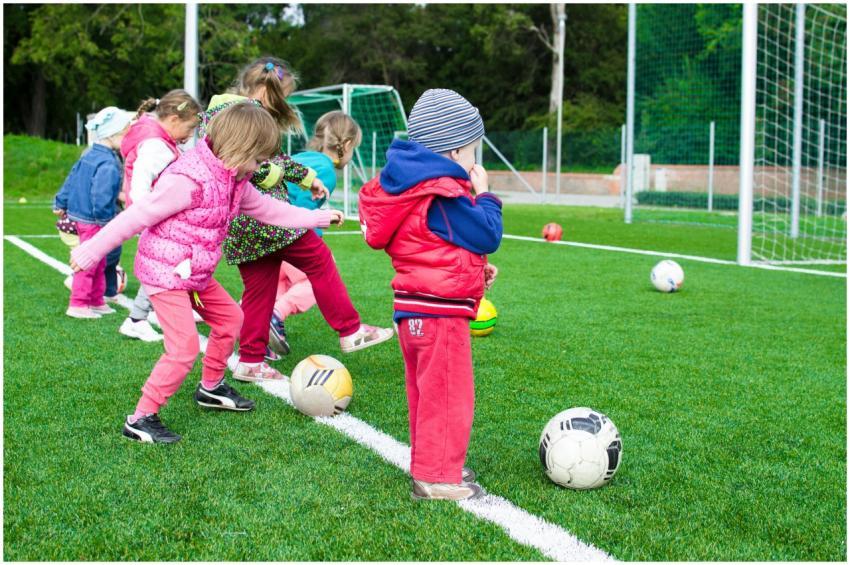 Kids having fun playing soccer outdoors on a sunny