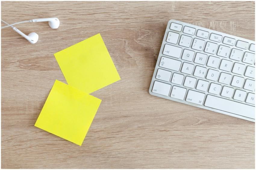 Top view of a workspace with a keyboard, earphones