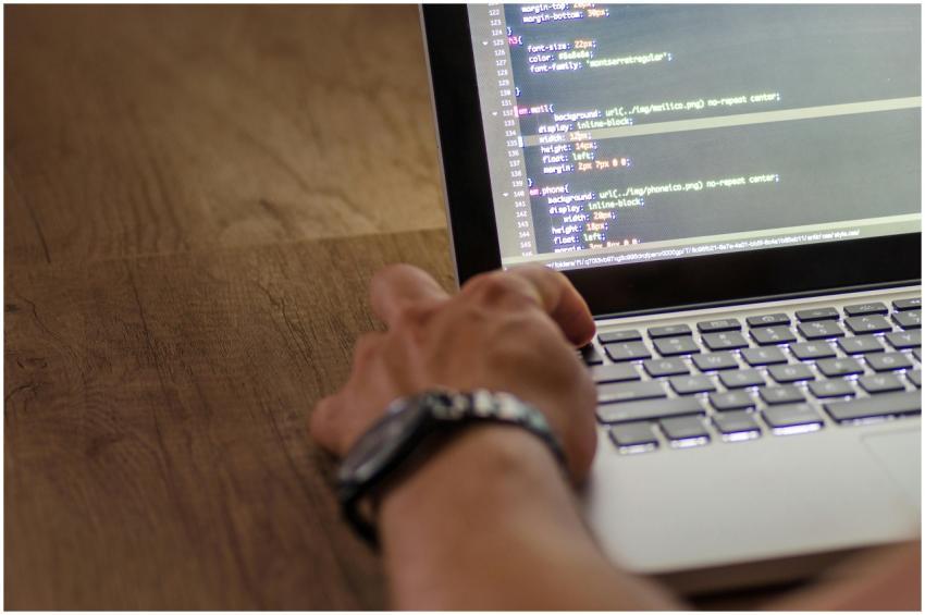 A developer's hand interacting with code on a lapt