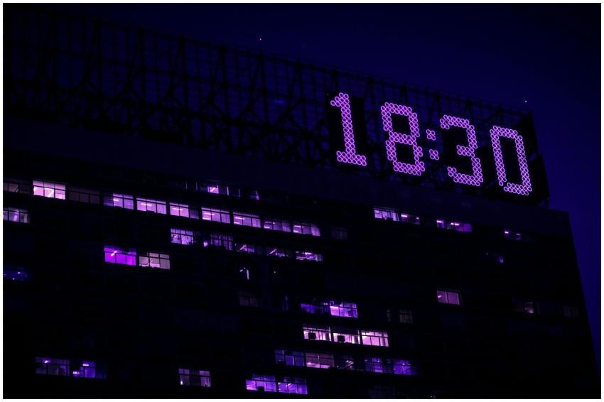 A modern building is illuminated at night with a p