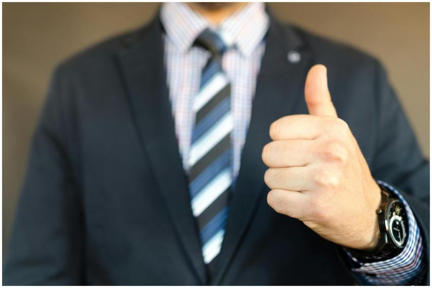 Close-up of a businessman in a suit giving a thumb