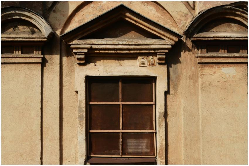 A vintage window on a rustic building exterior sho