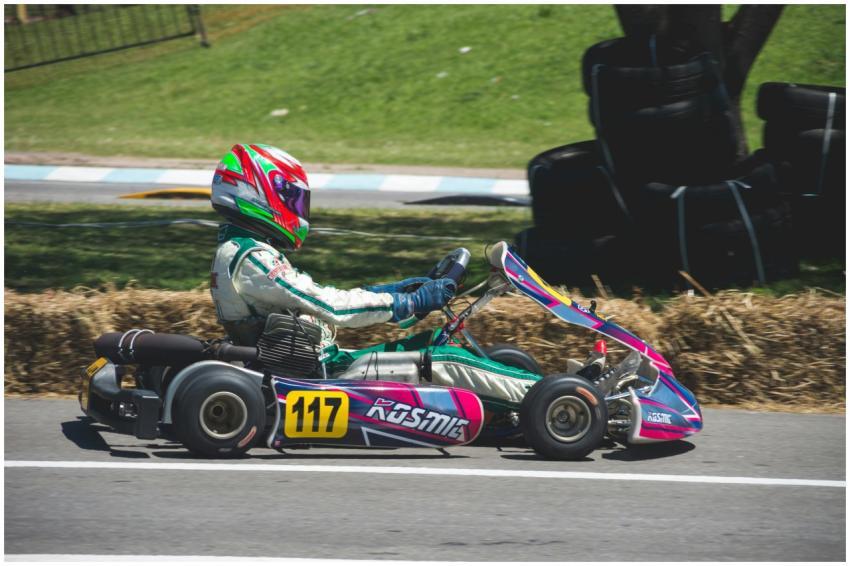 Go-kart racer speeding on an outdoor track under a