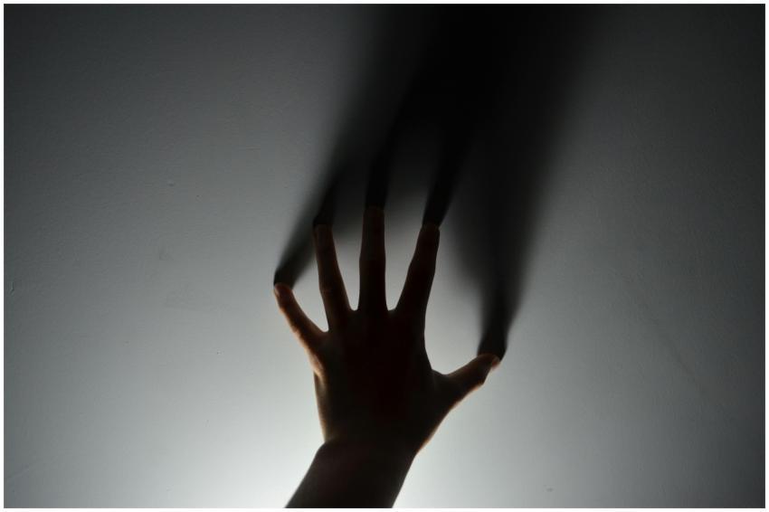 A mysterious silhouette of a hand casting a shadow