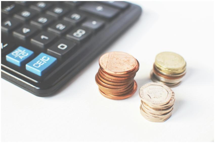 Close-up of stacked coins and a calculator symboli