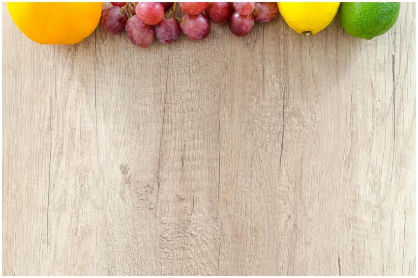 Fresh oranges, grapes, lemon, and lime arranged on