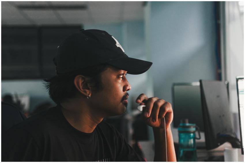 Side view of a focused man working on a computer i