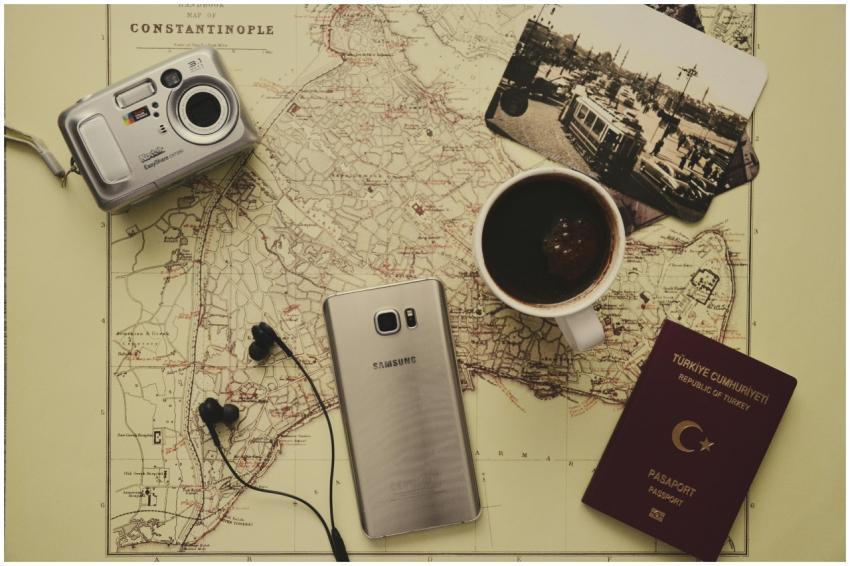 Flat lay of travel essentials including a map, pas