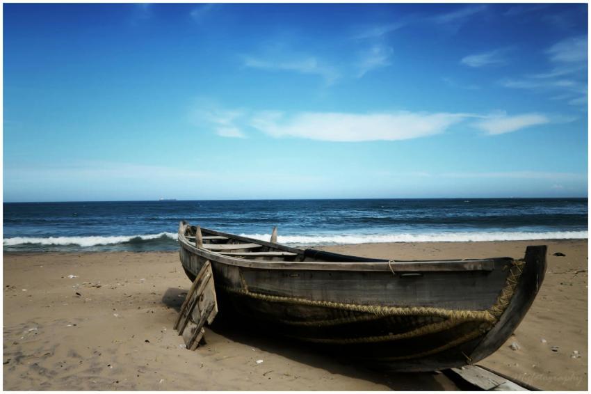 A serene scene of a rustic boat on the sandy shore
