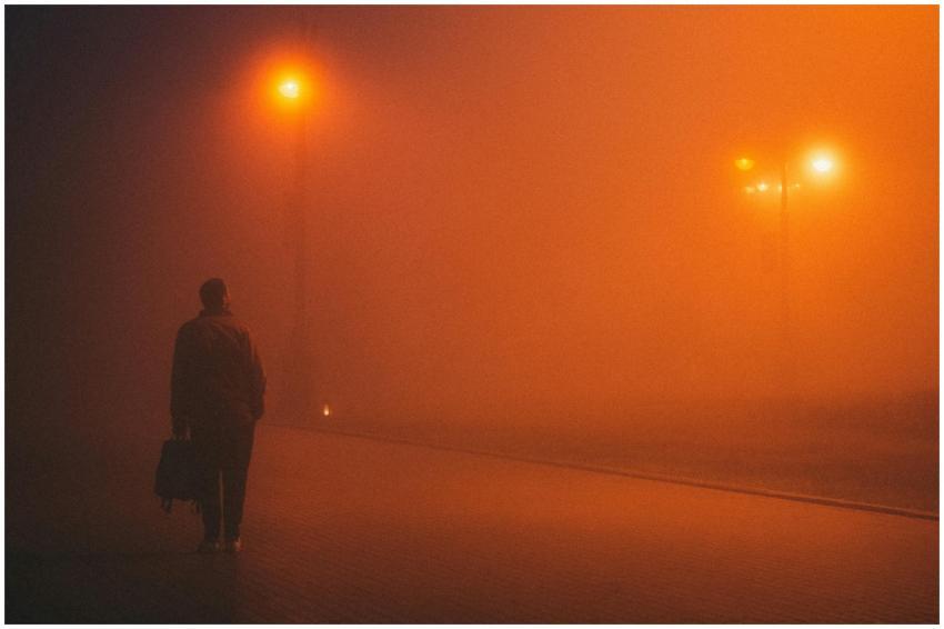 Silhouetted man on a foggy city street in Baku, il