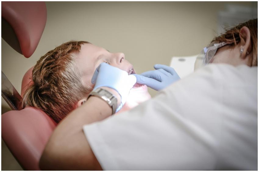 A young boy receiving a dental examination by a pr