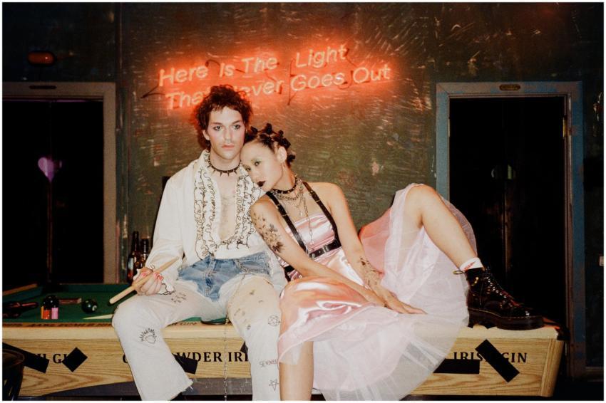 Fashionable couple in retro punk attire posing on