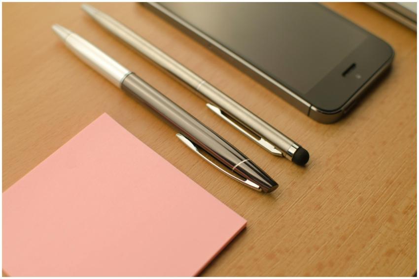 Stylish workspace featuring a smartphone, pens, an