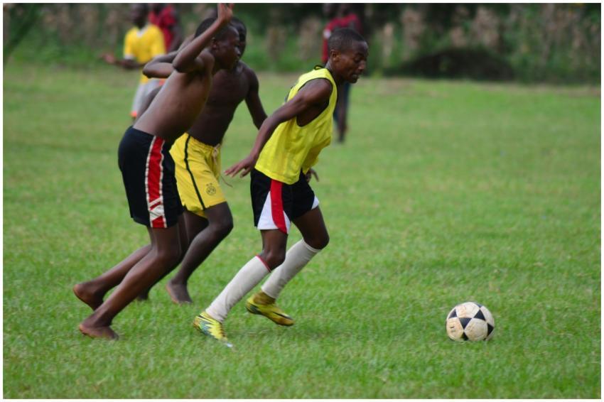Action shot of teenage boys playing soccer outdoor
