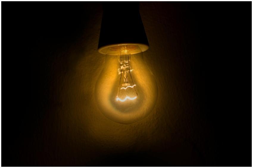 Warm glow of an illuminated light bulb against a d