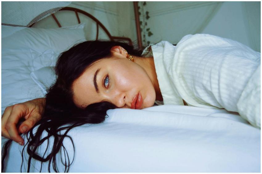 A serene portrait of a woman relaxing indoors, lyi