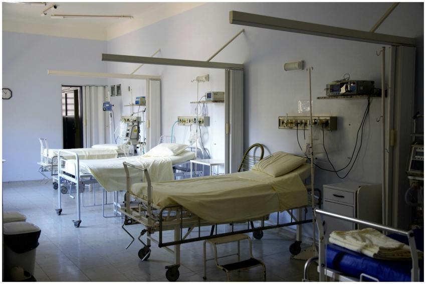 Spacious hospital room with several empty beds and