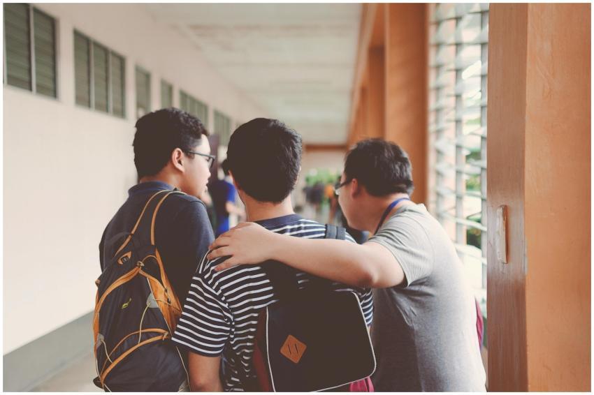 Group of male teenagers walking in a school corrid