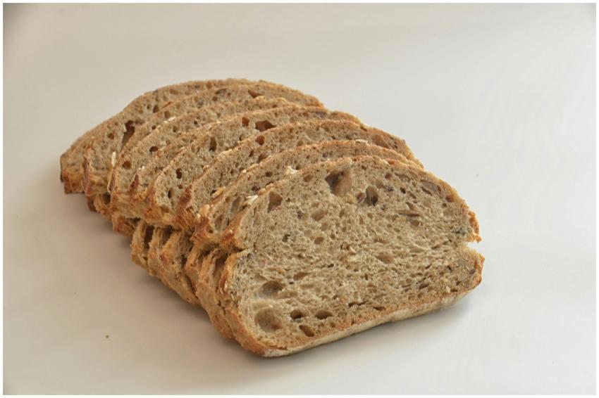 Close-up of sliced whole wheat bread on a white su