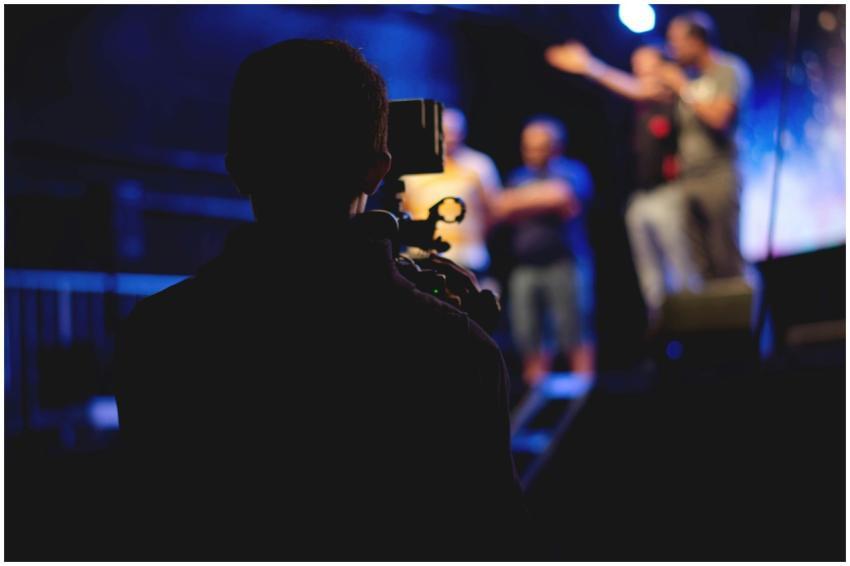 A cameraman films a live concert performance, capt