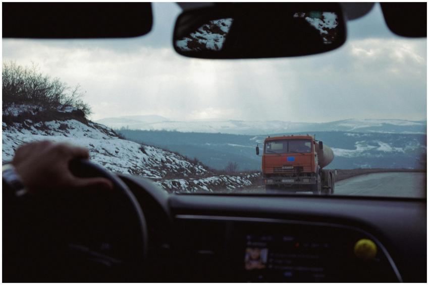 View from inside a car approaching a truck on a sn