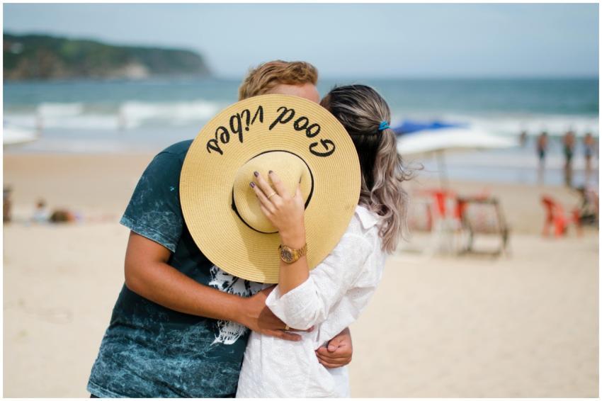 A couple shares a romantic kiss on a sunny beach,