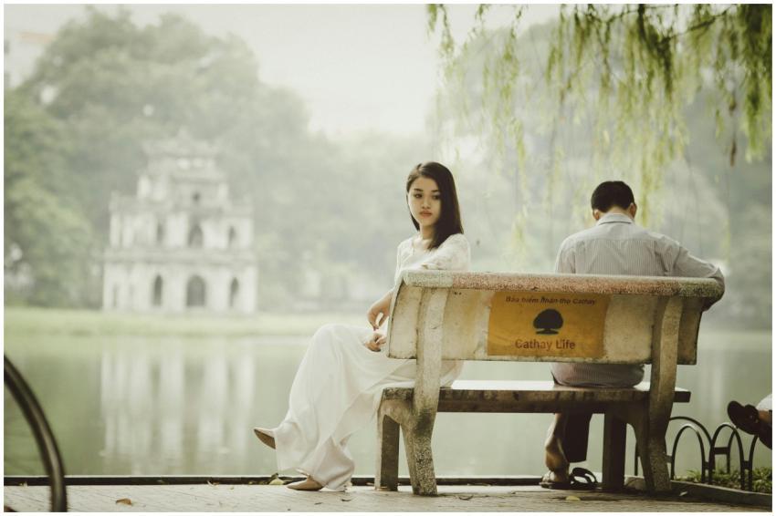 A couple sitting on a bench near Hanoi's iconic Tu