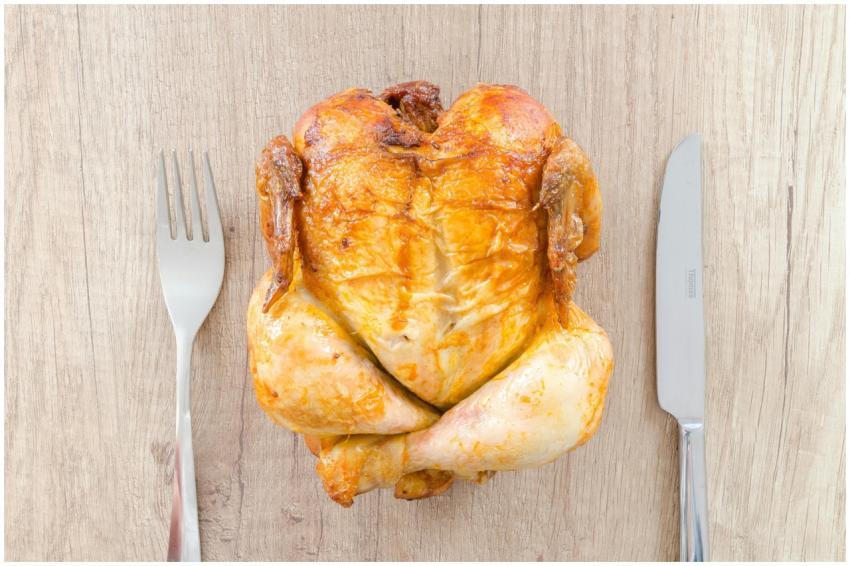 Top view of a perfectly roasted chicken placed bet