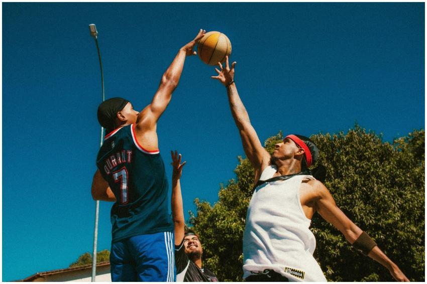 Energetic street basketball game with young men co