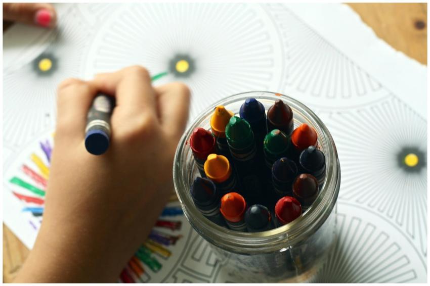 A child drawing with colorful crayons, fostering c