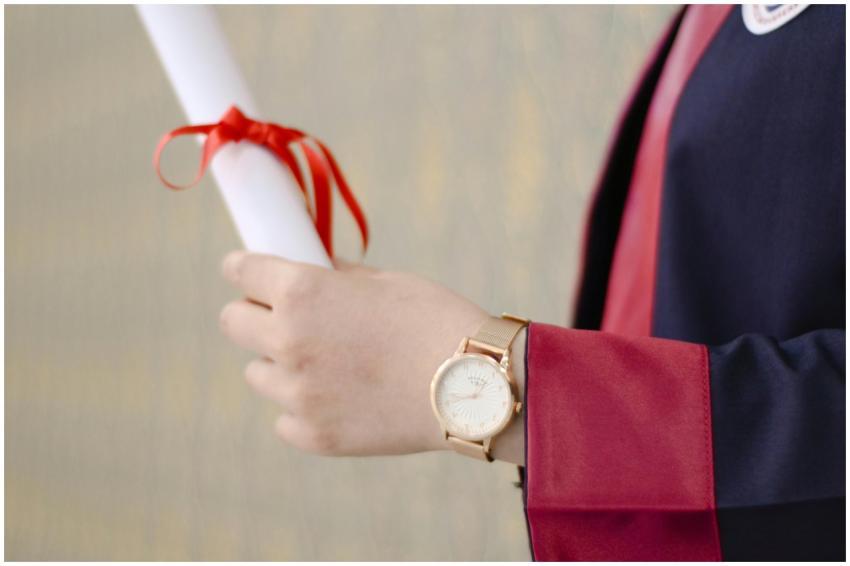 A close-up of a graduate's hand holding a diploma,