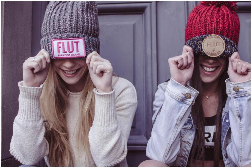 Two young women laughing and posing with colorful