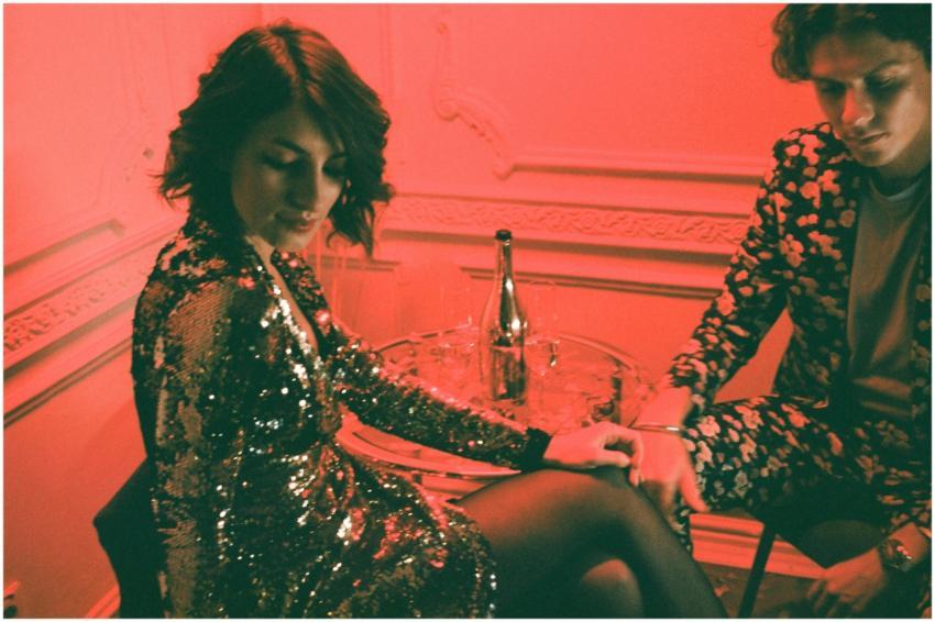 A stylish couple in glittering evening attire enjo