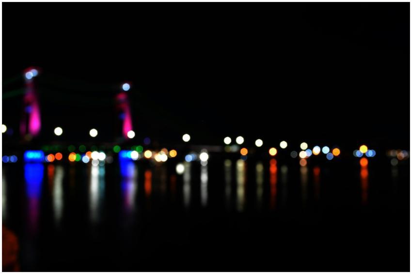 Blurred view of Ampera Bridge lights reflecting in