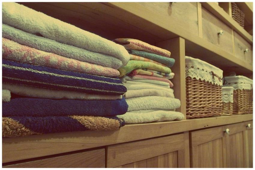 Tidy wooden cabinet with neatly stacked towels and