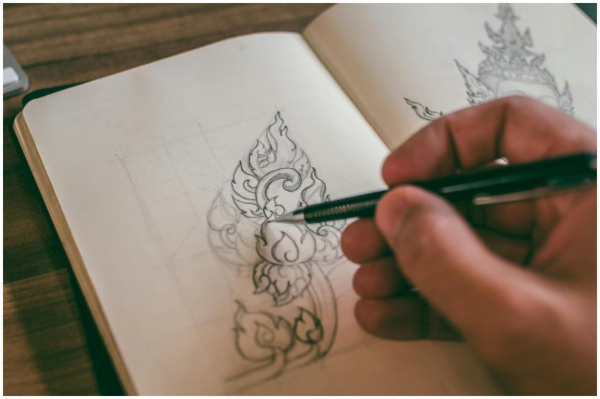 Close-up of a hand sketching detailed design in a