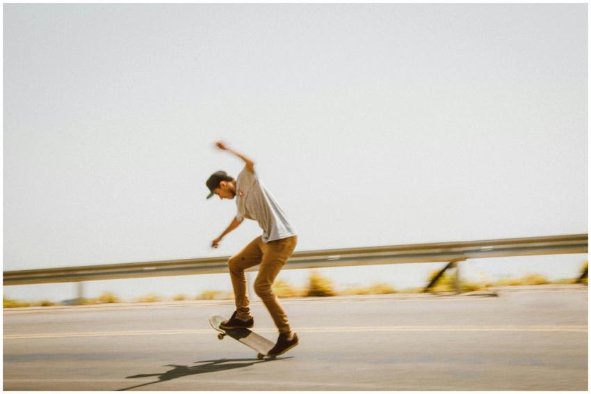 Young man skateboarding on an open road, displayin