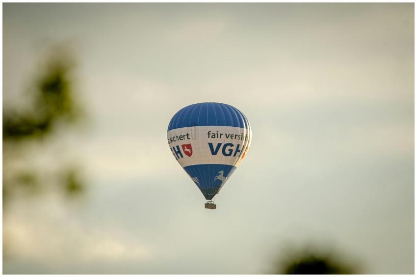 A blue hot air balloon with text flying in a clear