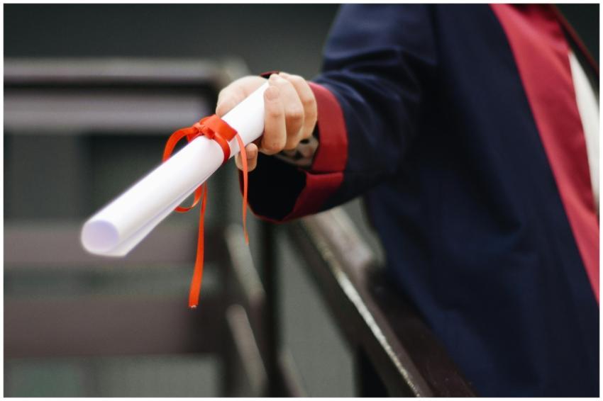 A close-up image of a graduate holding a diploma t