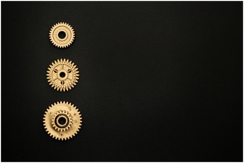 Close-up of three golden gears aligned vertically