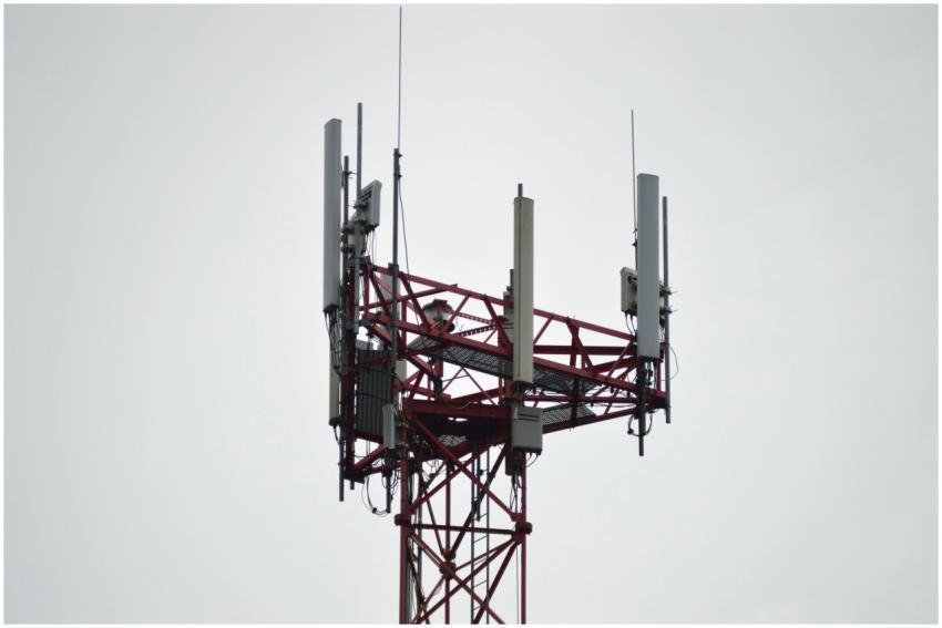 A red communication tower with antennas stands tal