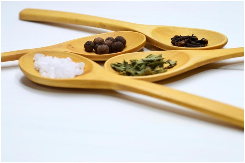 Wooden spoons showcasing salt, cloves, peppercorns