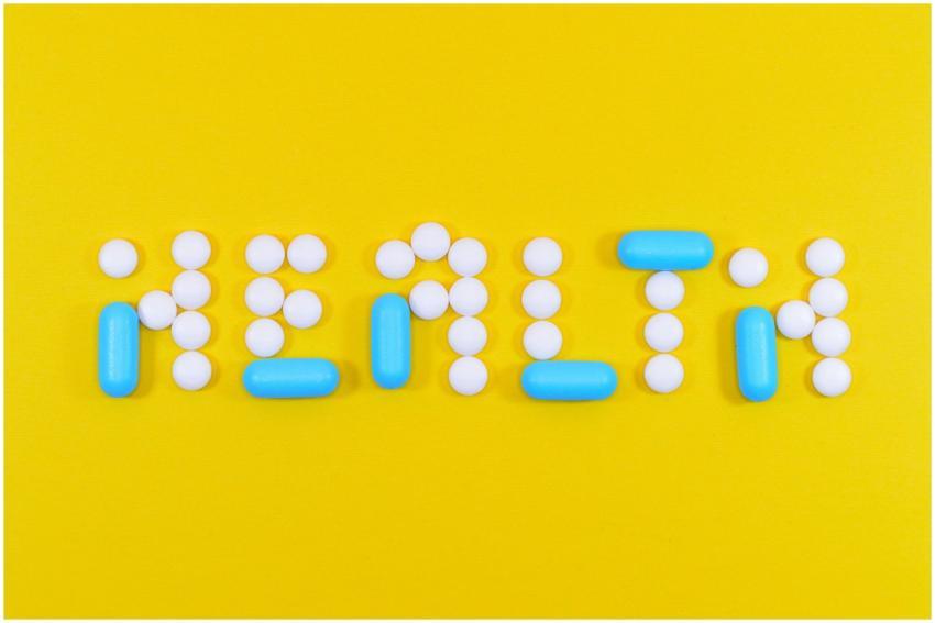 Pills spelling 'health' on a vibrant yellow backgr