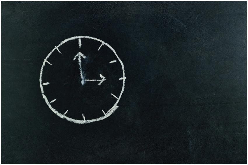 Chalk-drawn clock on a blackboard, symbolizing tim