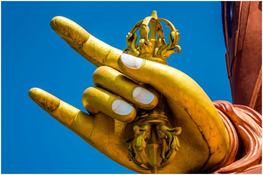 Close-up of a golden Buddha hand statue holding a