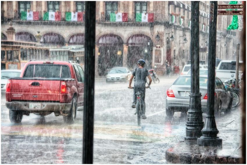 A cyclist rides through heavy rain in Morelia's ur
