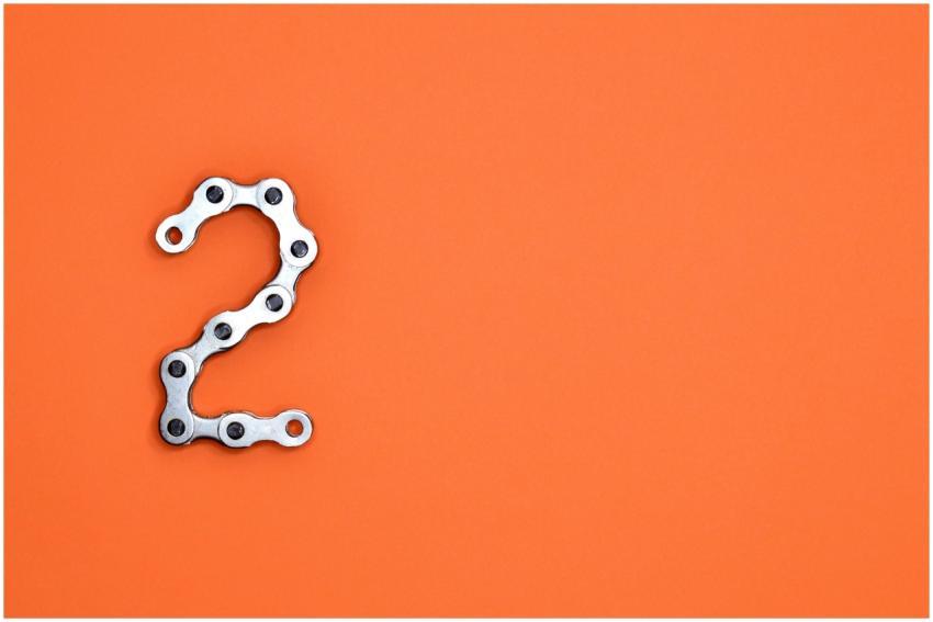 Metal chain forming the number 2 on a bright orang